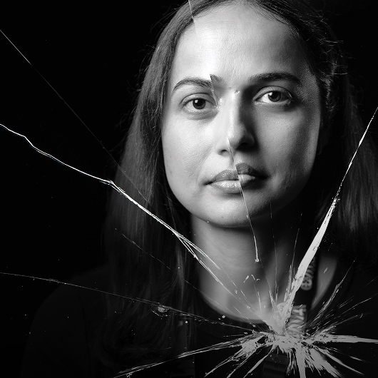 Profile of a woman behind shattered glass